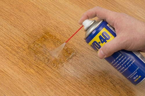 1. Breng de WD-40 royaal aan op de lijmresten